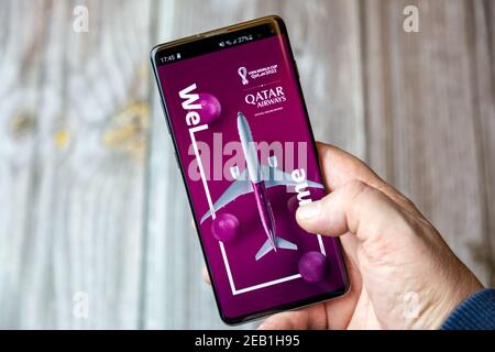 Ein Mobiltelefon oder Mobiltelefon, das von einem gehalten wird Hand mit der Qatar Airways App auf dem Bildschirm geöffnet Stockfoto