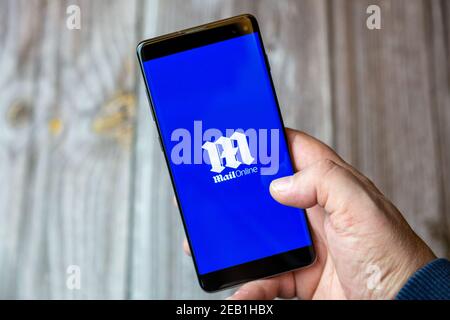 Ein Mobiltelefon oder Mobiltelefon, das von einem gehalten wird Hand mit der Daily Mail Online-App geöffnet auf dem Bildschirm Stockfoto