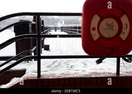 Schnee bedeckte den Pier in London South Bank hinter dem Rettungsring Life Saver in Red Box an der Themse River London Stockfoto