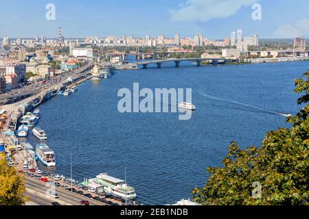 Eine Landschaft des Sommers Kiew mit Blick auf die Dnipro Böschung im alten Podil Bezirk, eine Flussstation, Piers, Flussbahnen und Vergnügungsboote. Stockfoto