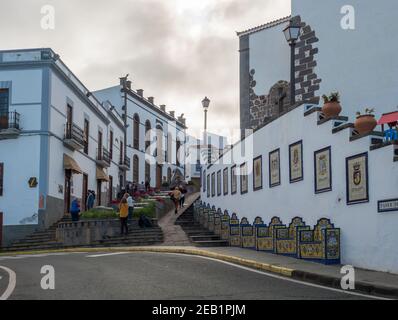 Firgas, Gran Canaria, Kanarische Inseln, Spanien 13. Dezember 2020: Blick auf die Straße Paseo de Gran Canaria mit Wasserfall Brunnen, Blumen und Keramik Stockfoto