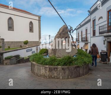 Firgas, Gran Canaria, Kanarische Inseln, Spanien 13. Dezember 2020: Blick auf die Straße Paseo de Gran Canaria mit Wasserfall Brunnen, Blumen und Keramik Stockfoto