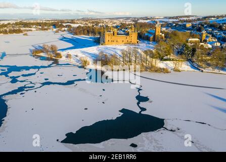 Winterszene Schottland: Luftaufnahme des Sonnenuntergangs auf Linlithgow Palace und Linlithgow Loch. Stockfoto