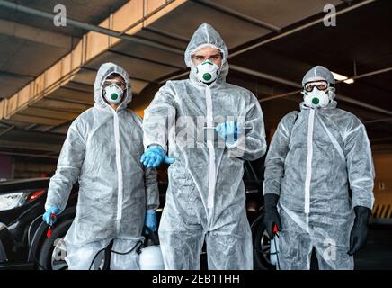 Mitarbeiter im Gesundheitswesen empfiehlt, die Quarantänezone nicht zu verlassen. Ein Team von Mitarbeitern im Gesundheitswesen, die Hazmat-Anzüge tragen, arbeitet zusammen, um einen Ausbruch zu kontrollieren Stockfoto