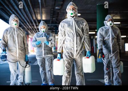 Team von Mitarbeitern im Gesundheitswesen tragen Gefahrgut Anzüge arbeiten zusammen Virenausbruch kontrollieren Stockfoto