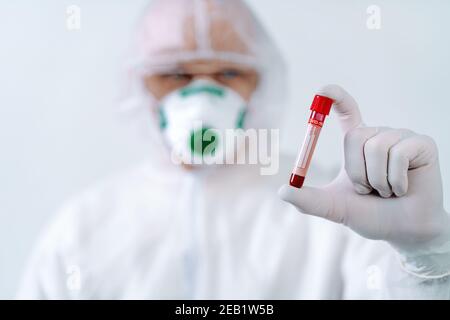 Gesundheitsarbeiter in Schutzanzug und medizinische Maske Bluttest Ergebnis für das neue, sich schnell ausbreitende Virus Stockfoto