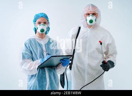 Mitarbeiter im Gesundheitswesen in Schutzanzügen und medizinischen Masken arbeiten zusammen Stockfoto