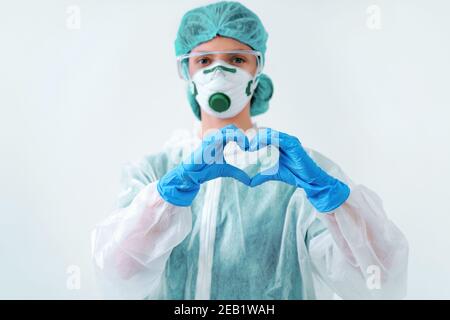 Gesundheitsarbeiter in Schutzanzug und medizinische Maske Formen Herz mit beiden Händen Stockfoto