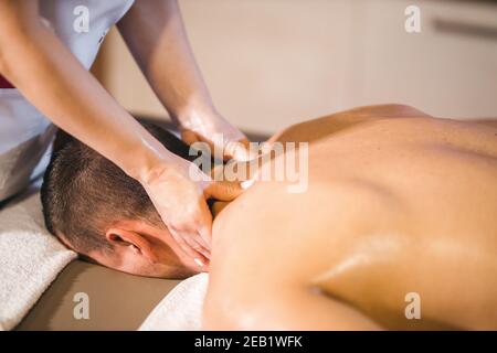 Flacher Fokus eines Mannes, der eine entspannende Rückenmassage hat Von einer Masseurin in einem Spa Stockfoto