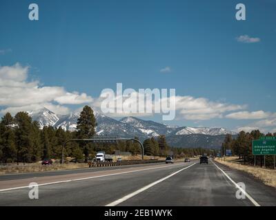 Roadtrip Fahrt auf dem Highway Interstate 17 in der Nähe von Flagstaff, Arizona mit über schneebedeckten San Francisco Gipfeln, ein erroded stratovulcano, im Frühjahr. Stockfoto