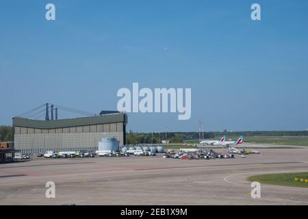 Berlin Deutschland - April 21. 2018: Flughafenausrüstung und Flugzeuge vor einem riesigen Hangar Stockfoto
