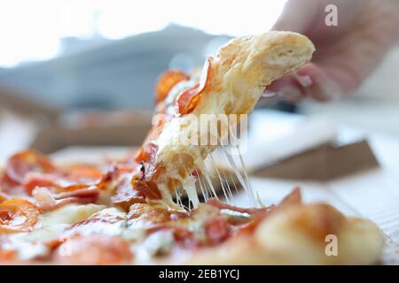 Frau Hand nimmt Stück Käse Pizza Stockfoto