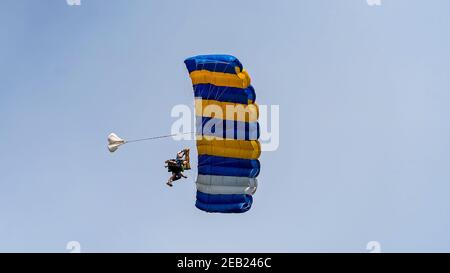 Airlie Beach, Queensland, Australien - Februar 2021: Tandem-Fallschirmspringer mit offenem Fallschirm kommen an Land Stockfoto