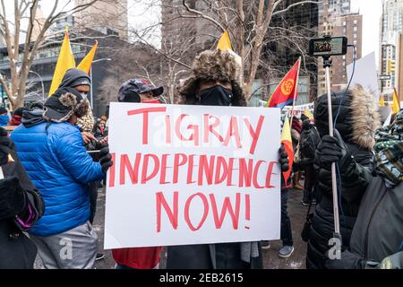 New York, Usa. Februar 2021, 11th. Demonstranten mit Tigray-Flaggen und Plakaten veranstalteten am 11. Februar 2021 eine Kundgebung auf dem Dag Hammarskjold Plaza in New York, in der sie forderten, das Ende des Athiopien-Angriffs auf Zivilisten zu fordern. Der Konflikt zwischen der Regionalregierung Tigray und der äthiopischen Regierung begann 2019 und eskalierte am 4. November 2020 zu einem offenen Krieg. Mehr als 2,3 Millionen Kinder werden von dringend benötigter Hilfe und humanitärer Hilfe abgeschnitten. Viele Demonstranten trugen Jacken, Hut und Gesichtsmasken in Farben der Tigray-Flagge. (Foto von Lev Radin/Sipa USA) Quelle: SIPA USA/Alamy Live News Stockfoto