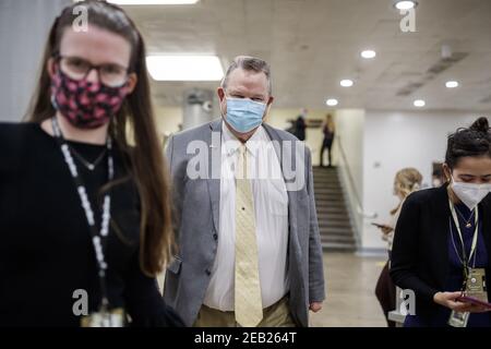 Washington, Usa. Februar 2021, 11th. Senator Jon Tester, ein Demokrat aus Montana, trägt eine Schutzmaske, während er am Ende des dritten Tages des zweiten Amtsenthebungsverfahrens im Capitol in Washington, DC, am Donnerstag, dem 11. Februar 2021 durch die Senatsbahn geht. Argumente werden heute im Amtsenthebungsverfahren gegen den ehemaligen Präsidenten Donald Trump präsentiert. Pool Foto von Ting Shen/UPI Kredit: UPI/Alamy Live Nachrichten Stockfoto