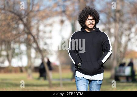 Portrait eines jungen Mannes Afro Hair Walking in Forest Durch den Wald draußen im Herbst Stockfoto