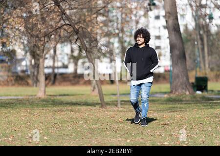 Portrait eines jungen Mannes Afro Hair Walking in Forest Durch den Wald draußen im Herbst Stockfoto