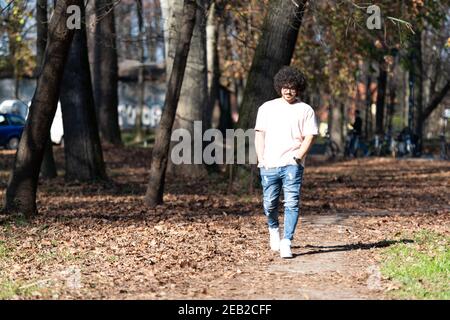 Portrait eines jungen Mannes Afro Hair Walking in Forest Durch den Wald draußen im Herbst Stockfoto