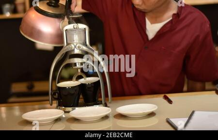 Barista Café bereiten Espresso und vietnam Kaffee Getränke im Café. Portrait eines Coffee-Shop Mitarbeiter Kaffee an der Bar. Der Prozess o Stockfoto