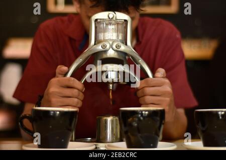 Barista Café bereiten Espresso und vietnam Kaffee Getränke im Café. Portrait eines Coffee-Shop Mitarbeiter Kaffee an der Bar. Der Prozess o Stockfoto