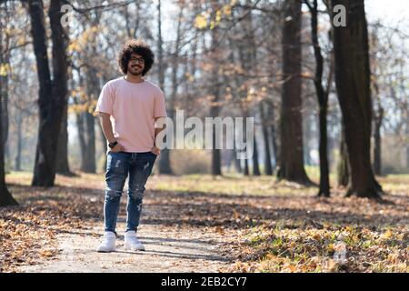 Portrait eines jungen Mannes Afro Hair Walking in Forest Durch den Wald draußen im Herbst Stockfoto