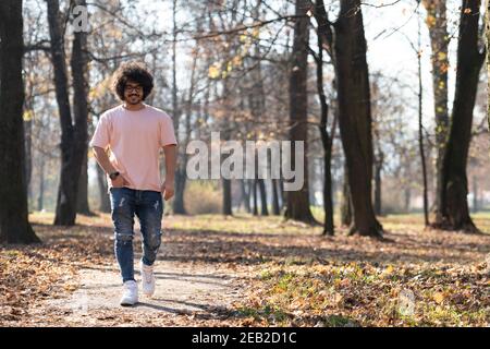 Portrait eines jungen Mannes Afro Hair Walking in Forest Durch den Wald draußen im Herbst Stockfoto