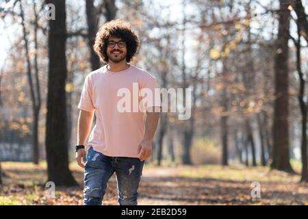 Portrait eines jungen Mannes Afro Hair Walking in Forest Durch den Wald draußen im Herbst Stockfoto