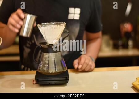 Barista Café bereiten Espresso und vietnam Kaffee Getränke im Café. Portrait eines Coffee-Shop Mitarbeiter Kaffee an der Bar. Der Prozess o Stockfoto