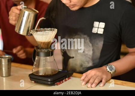 Barista Café bereiten Espresso und vietnam Kaffee Getränke im Café. Portrait eines Coffee-Shop Mitarbeiter Kaffee an der Bar. Der Prozess o Stockfoto