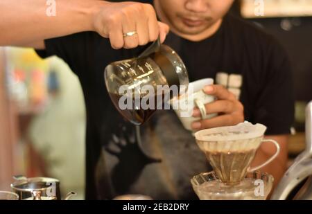 Barista Café bereiten Espresso und vietnam Kaffee Getränke im Café. Portrait eines Coffee-Shop Mitarbeiter Kaffee an der Bar. Der Prozess o Stockfoto