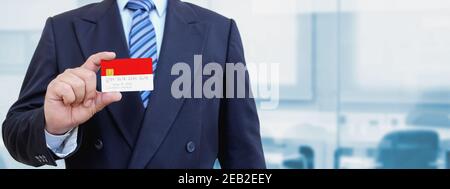 Zugeschnittenes Bild von Geschäftsmann mit Plastikkreditkarte mit bedruckter Flagge Indonesiens. Hintergrund unscharf. Stockfoto