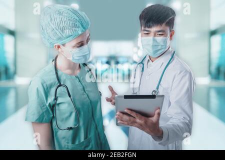 Diskussion des Ärzteteams Patientendiagnosebericht auf Tablette gegen Patienten Krankenstation Hintergrund, Gruppe von Ärzten Teamarbeit in medizinischen Geräten Arbeiten in Stockfoto
