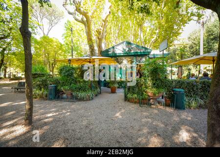 Ein malerisches, malerisches Café mit Garten und Innenhof umgeben von Bäumen und Efeu im Park der Villa Borghese in Rom, Italien Stockfoto