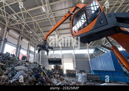 Abfallsortierungs- und Recycling-Anlage. Ladekran und Greifkran handhaben Abfall Stockfoto