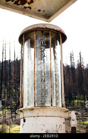 Rostige Vintage-Gaspumpe in Dardanelle Township nach 2018 Donnell Fire. Tote verbrannte Bäume auf Highway 108, Sonora Pass, Stanislaus National Forest, CA. Stockfoto