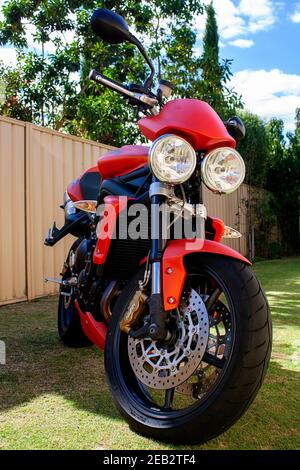 2010 Triumph Street Triple R oranges Motorrad, Vorderansicht, geparkt auf Gras Stockfoto