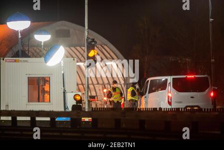 Kiefersfelden, Deutschland. Februar 2021, 12th. Beamte der Bundespolizei kontrollieren Personen, die aus Österreich mit dem Auto an der Grenzstelle zwischen Kufstein (Österreich) und Kiefersfelden (Deutschland) ankommen. Im Kampf gegen die sich ausbreitende südafrikanische Corona-Variante hat die österreichische Provinz Tirol in der Nacht neue Austrittsbeschränkungen durchgesetzt. Kredit: Peter Kneffel/dpa/Alamy Live Nachrichten Stockfoto