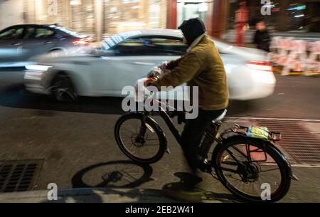 Fahrradfahrer fahren auf der Straße in der Chinatown Nachbarschaft von New York City. Stockfoto