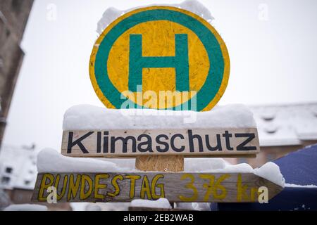 Nürnberg, Deutschland. Februar 2021, 09th. Am Eingang des Klimacamps in der Innenstadt steht eine selbst gestaltete Bushaltestelle mit dem Namen "Klimaschutz". Trotz eisiger Temperaturen bleiben Klimaaktivisten im Lager bestehen. Seit September demonstrieren sie mit einer kontinuierlichen Mahnwache in Sichtweite des Rathauses für mehr Klimaschutz. Quelle: Daniel Karmann/dpa/Alamy Live News Stockfoto