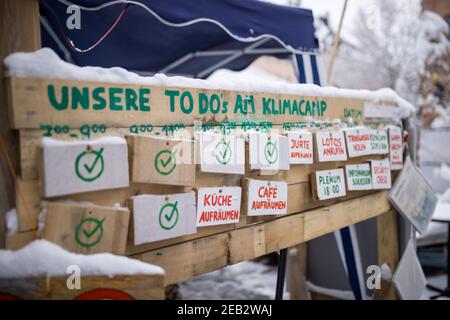 Nürnberg, Deutschland. Februar 2021, 09th. Auf einem Holzbrett am Eingang des Klimacamps in der Innenstadt sind die "To dos" für die Mitglieder des Camps. Trotz eisiger Temperaturen bleiben Klimaaktivisten im Lager bestehen. Seit September demonstrieren sie mit einer kontinuierlichen Mahnwache in Sichtweite des Rathauses für mehr Klimaschutz. Quelle: Daniel Karmann/dpa/Alamy Live News Stockfoto