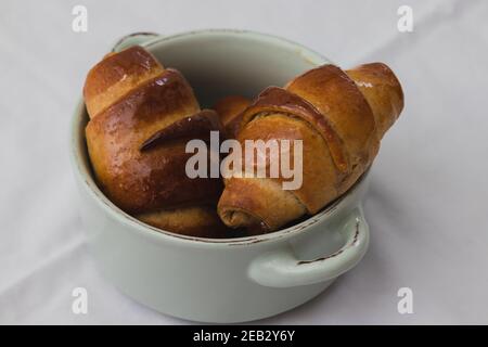 Hausgemachte Vollkornmehl Croissants, in einem kleinen Keramiktopf Stockfoto