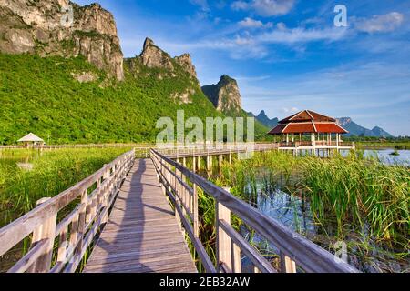 Holzbrücken und kleine Pavillons mit Blick auf die Berge. Es gibt einen blauen Himmel am Abend im Lotus Pond ist ein Nationalpark in Sam ROI Yot District, P Stockfoto