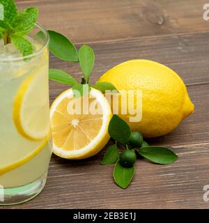 Erfrischender Limonensaft trinken Sie im Glas mit Zitronen auf Holztisch Hintergrund Stockfoto