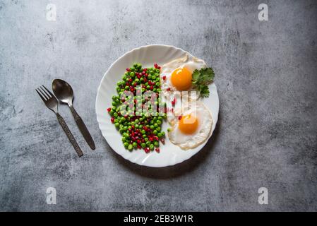 Bohnen und eierpoaches sind ein beliebtes Frühstückszutat. Draufsicht, selektiver Fokus. Stockfoto