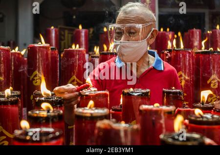 Medan, Indonesien. Februar 2021, 12th. Ein älterer Mann brennt eine Kerze, als er am ersten Tag des chinesischen Neujahrsmonats im Dharma Ramsi Tempel in Bandung, West Java, Indonesien, am 12. Februar 2021 betet. Quelle: Septianjar/Xinhua/Alamy Live News Stockfoto