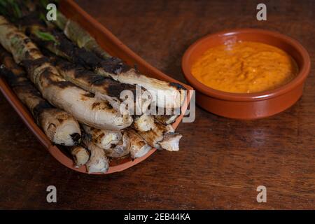 Nahaufnahme einer Platte gegrillte Calcots, katalanische süßen Zwiebeln und eine Schüssel mit Romesco-sauce Stockfoto