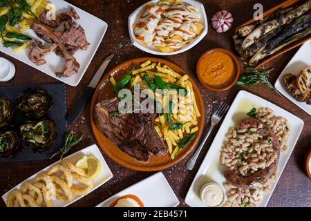 Typisch spanische Mischgerichte auf dunkelbraunem Holztisch. Draufsicht Stockfoto