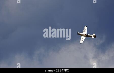 1936 Percival Mew Gull G-AEXF Flugzeuge im Flug mit blauem Himmel und Wolken. Stockfoto