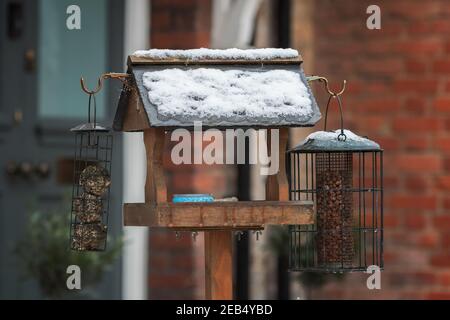 Vogelfutterhäuschen und Vogelhaus im Winter von Schnee bedeckt, London Street Stockfoto