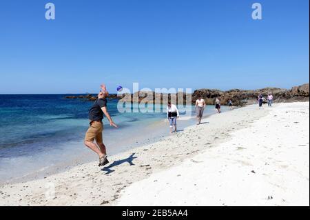 Mann, der versucht, einen Ball im Nordwesten zu fangen Strand auf Iona Stockfoto